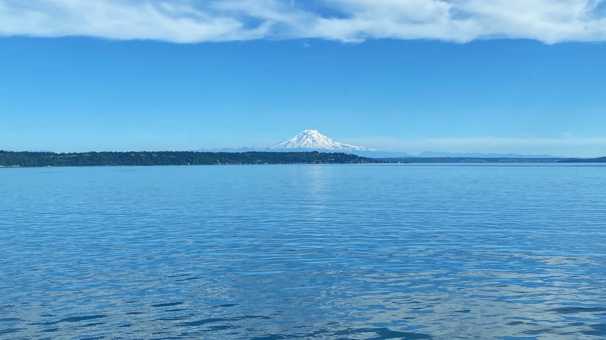 Mount Rainier on the horizon across Puget Sound, under a blue sky